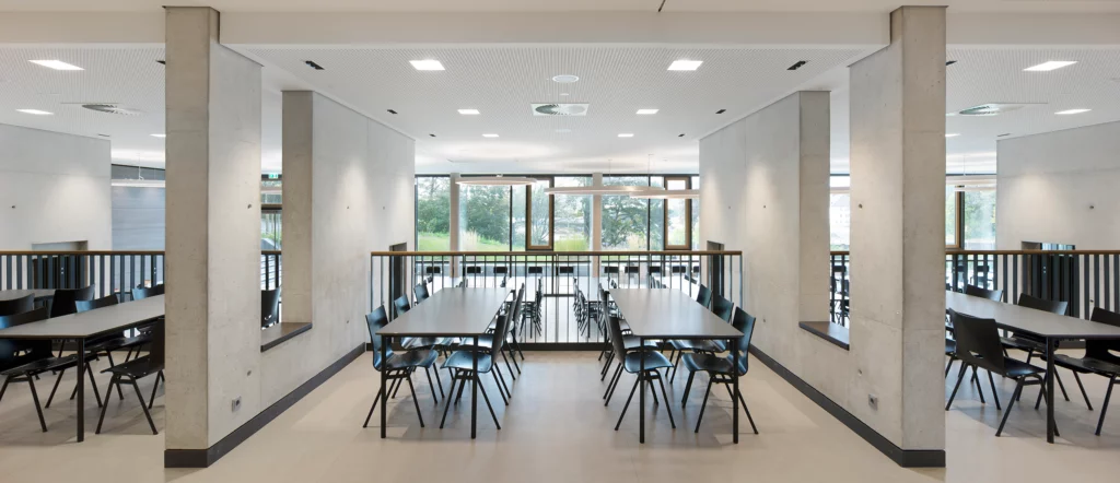 Schulzentrum Nord Hamlen Innenaufnahme Mensa Sitzinseln zwischen Wandnischen Blick nach Draußen